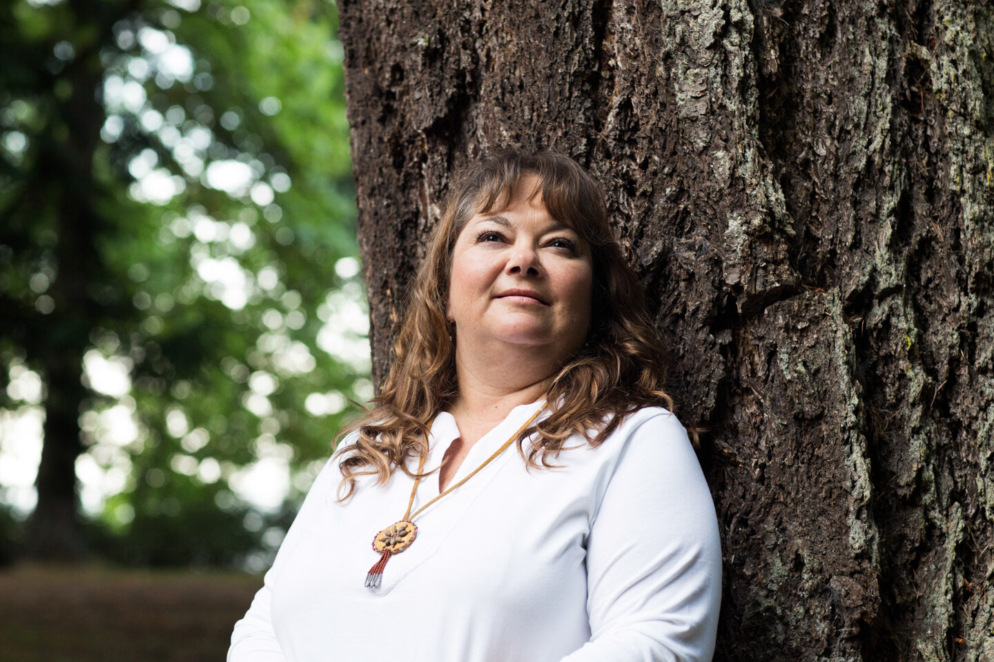 Photo of Monique Gray Smith leaning against a tree.